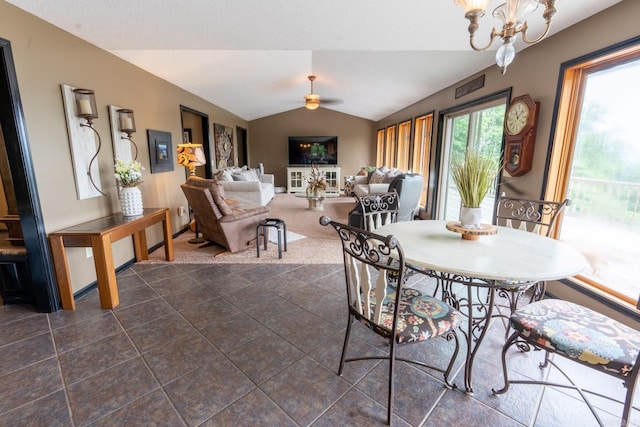 dining room featuring ceiling fan with notable chandelier and lofted ceiling