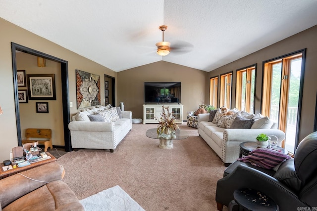 living area with a textured ceiling, lofted ceiling, carpet, and a ceiling fan