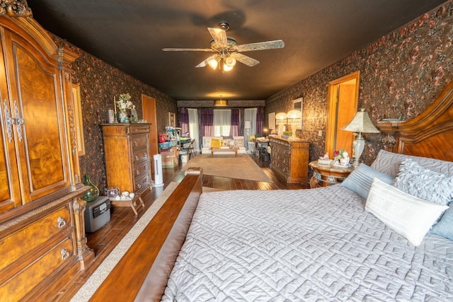 bedroom with wood finished floors and wallpapered walls