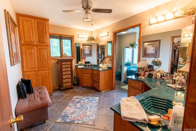 bathroom with tile patterned floors, a textured ceiling, vanity, and a ceiling fan