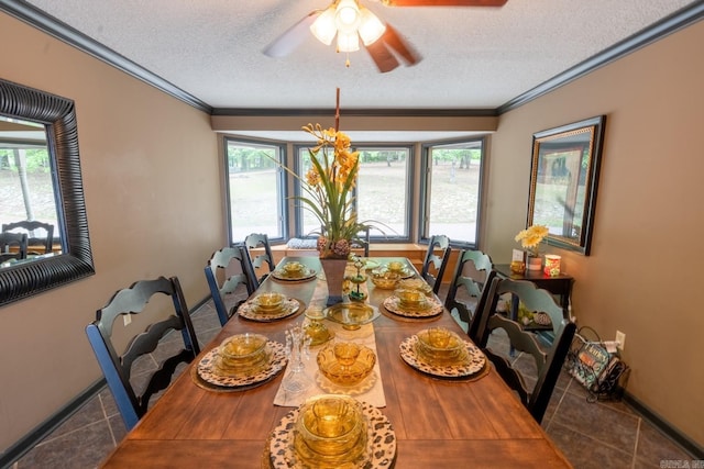 tiled dining space with a ceiling fan, baseboards, a textured ceiling, and crown molding