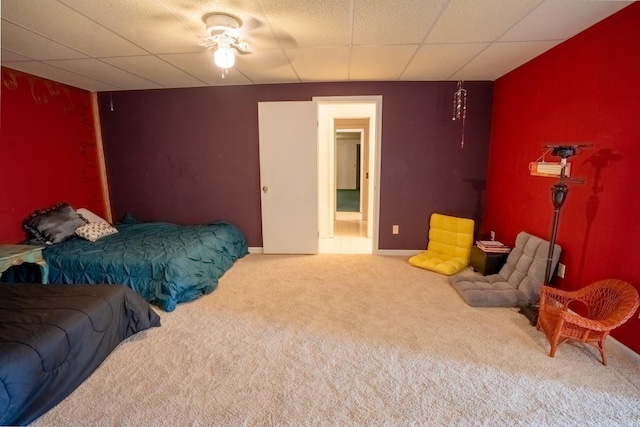 carpeted bedroom with a drop ceiling, baseboards, and connected bathroom