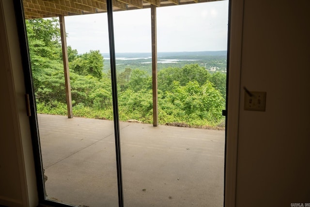 doorway to outside featuring a forest view and a wealth of natural light