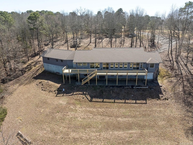 rear view of property with stairway, a view of trees, and a deck