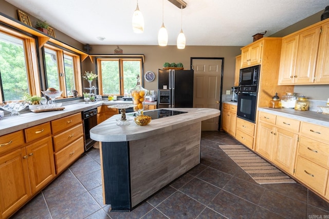 kitchen with light brown cabinets, a kitchen island, butcher block countertops, hanging light fixtures, and black appliances