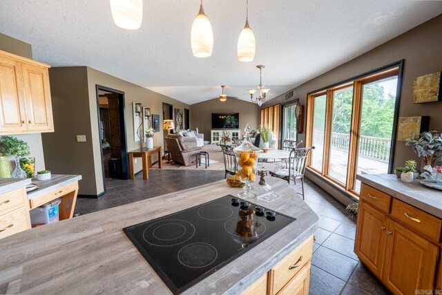 kitchen with lofted ceiling, a textured ceiling, light countertops, black electric stovetop, and hanging light fixtures