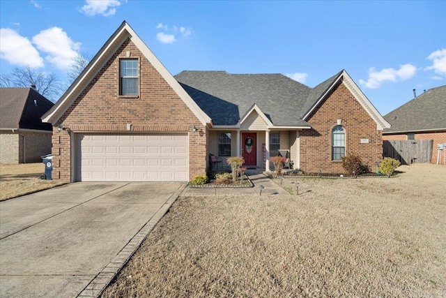 traditional-style house with a garage, fence, brick siding, and driveway