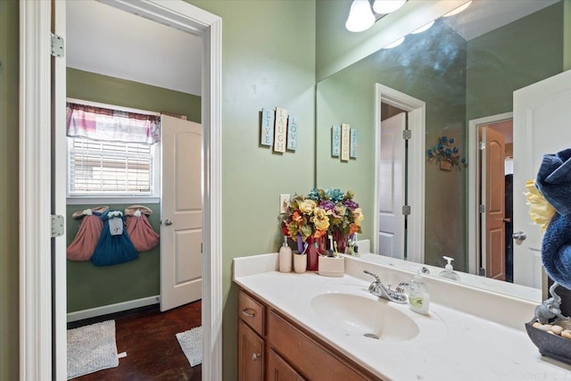 bathroom with vanity, wood finished floors, and baseboards