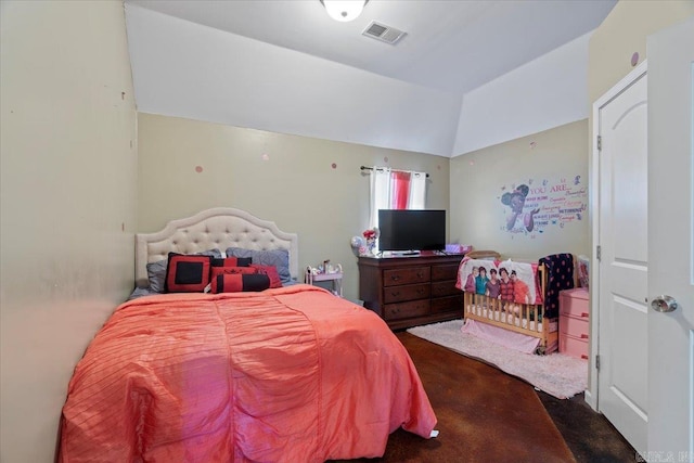 carpeted bedroom with visible vents and vaulted ceiling