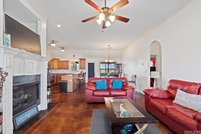 living area with crown molding, a fireplace with flush hearth, arched walkways, and concrete floors