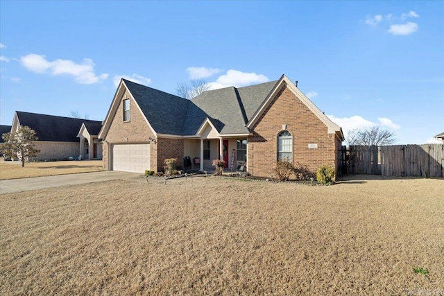 view of front of house with brick siding, concrete driveway, a front yard, and fence