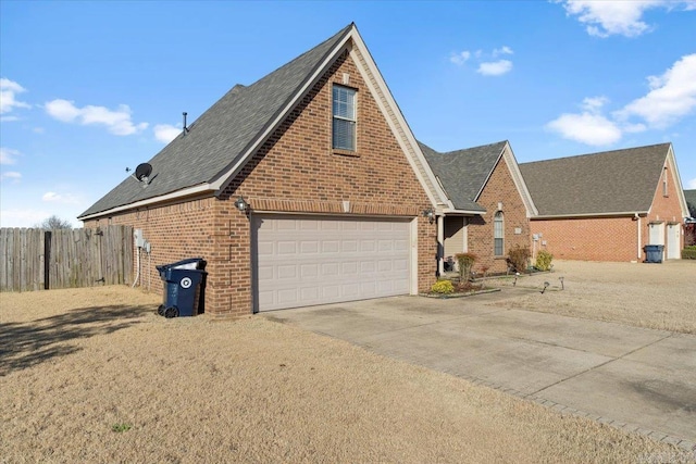 view of side of home featuring a garage, fence, brick siding, and driveway