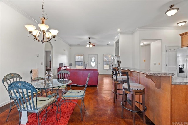 dining room with ceiling fan, baseboards, arched walkways, and finished concrete floors