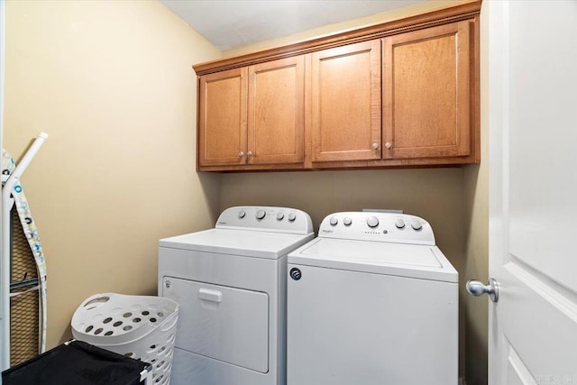 clothes washing area featuring cabinet space and independent washer and dryer