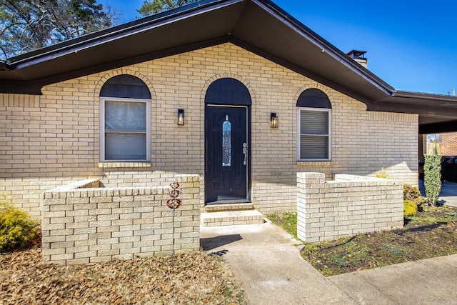 doorway to property featuring brick siding