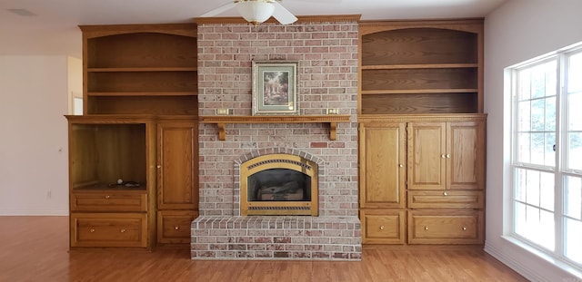 unfurnished living room with a fireplace, plenty of natural light, and light wood-style floors