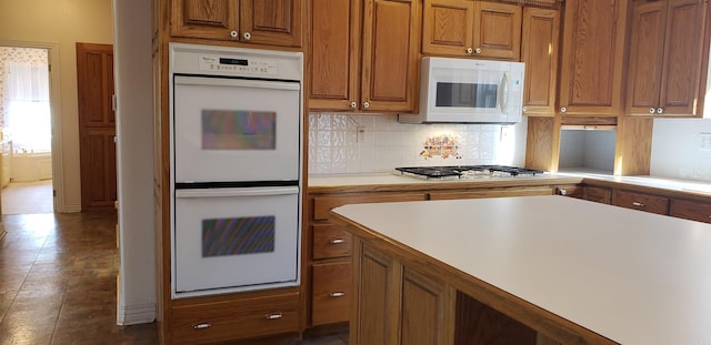 kitchen featuring white appliances, tasteful backsplash, light countertops, and brown cabinets