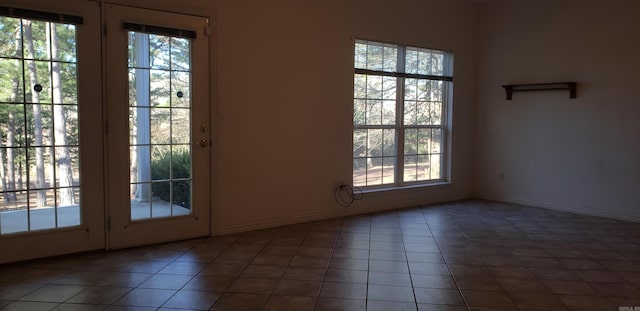 doorway featuring tile patterned floors and baseboards