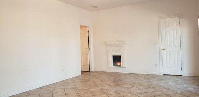 empty room with baseboards and a warm lit fireplace