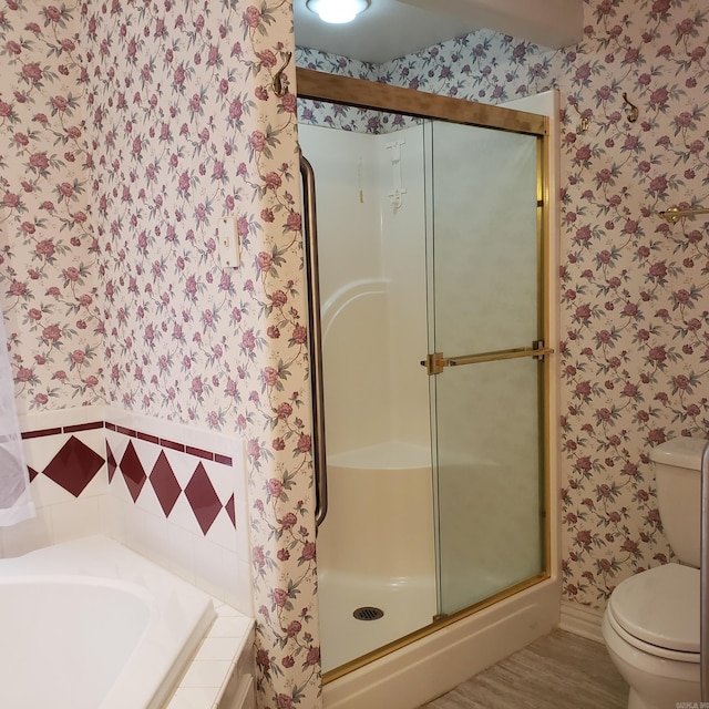 full bathroom featuring wallpapered walls, a garden tub, toilet, and a stall shower