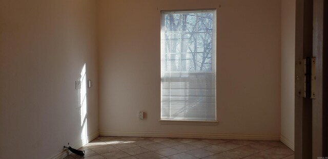 empty room featuring light tile patterned floors and baseboards