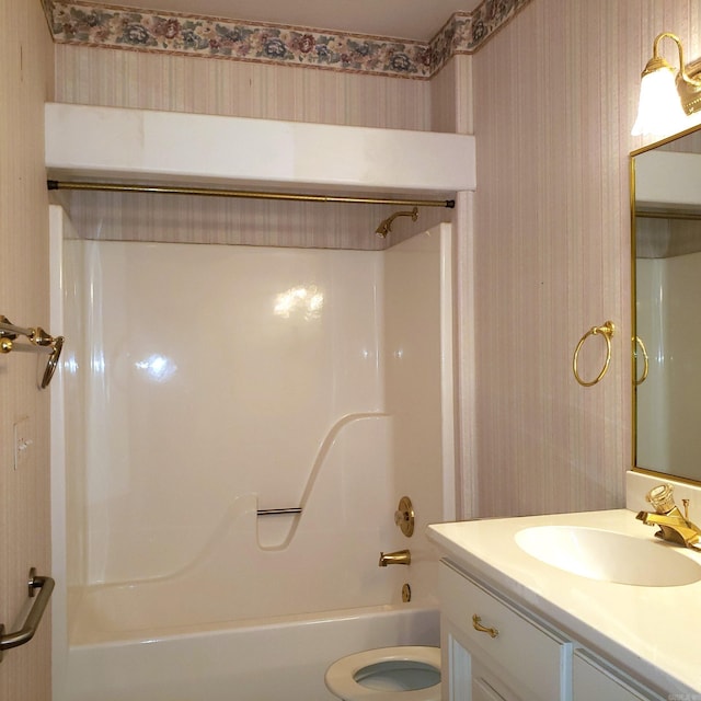 bathroom featuring toilet,  shower combination, vanity, and wallpapered walls