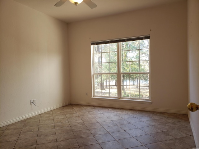 tiled spare room with a ceiling fan, baseboards, and a wealth of natural light