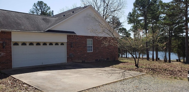 view of home's exterior with a shingled roof, concrete driveway, a garage, crawl space, and brick siding