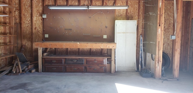 miscellaneous room featuring a workshop area and concrete flooring