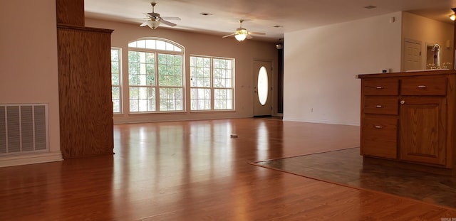 foyer entrance featuring visible vents, baseboards, wood finished floors, and a ceiling fan