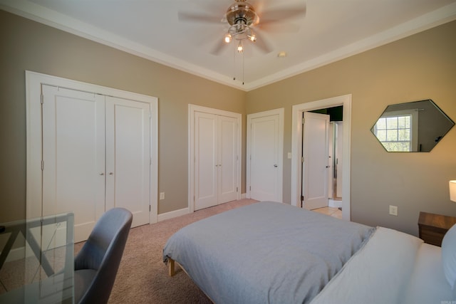 bedroom with two closets, crown molding, baseboards, light colored carpet, and ceiling fan