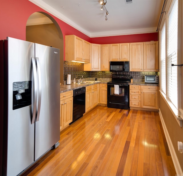 kitchen with black appliances, light brown cabinetry, and light wood finished floors