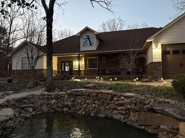 view of front of home with stone siding and covered porch