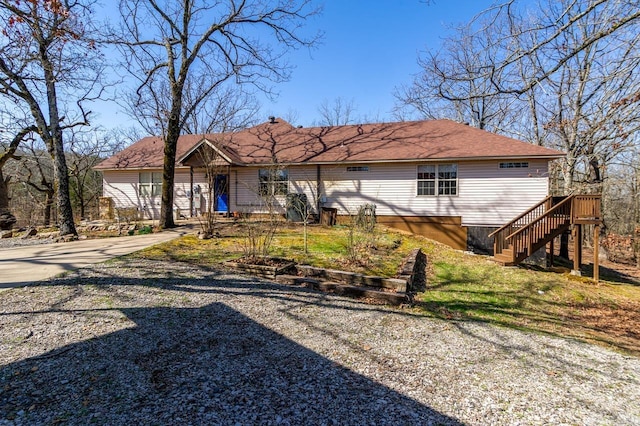 rear view of property featuring stairway and driveway