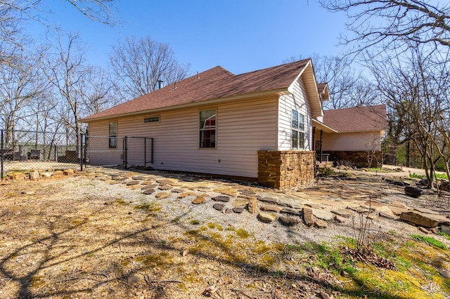 view of side of home with a gate and fence