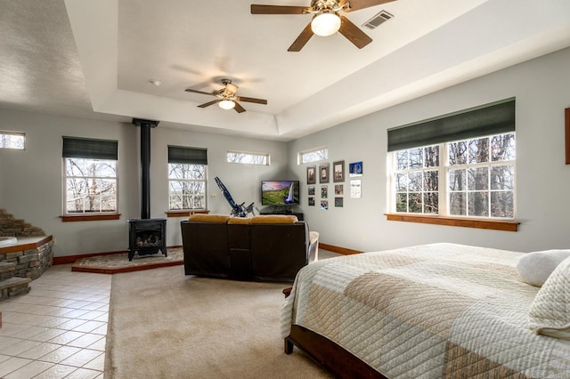 bedroom with light tile patterned floors, visible vents, multiple windows, and a raised ceiling