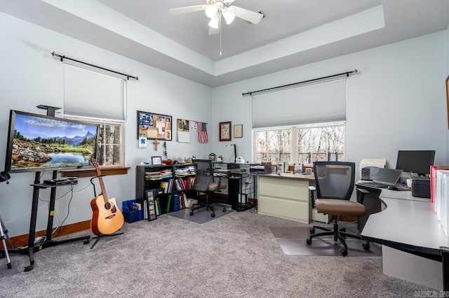 office area with a raised ceiling, ceiling fan, and carpet floors