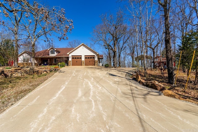 view of front of home featuring stone siding, driveway, and a garage