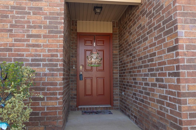 view of exterior entry featuring brick siding