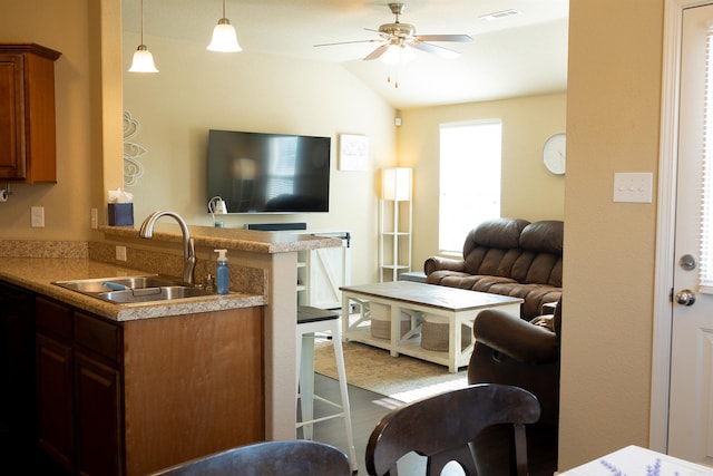 living area featuring lofted ceiling, visible vents, and ceiling fan