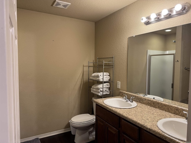 bathroom with a sink, visible vents, double vanity, and a shower stall