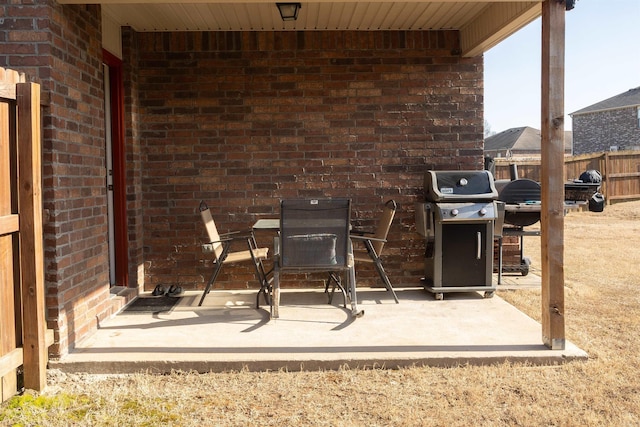 view of patio with grilling area, outdoor dining space, and fence