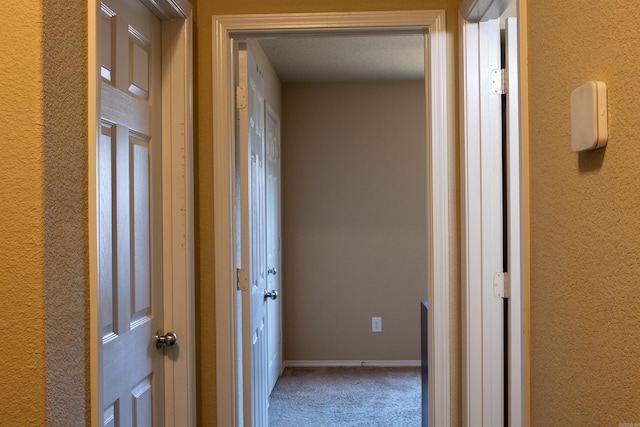 hall with carpet flooring and baseboards