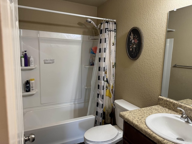 bathroom featuring vanity, toilet, a textured wall, and shower / bath combo