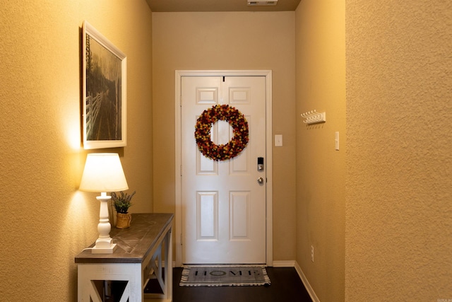 doorway to outside featuring visible vents and baseboards