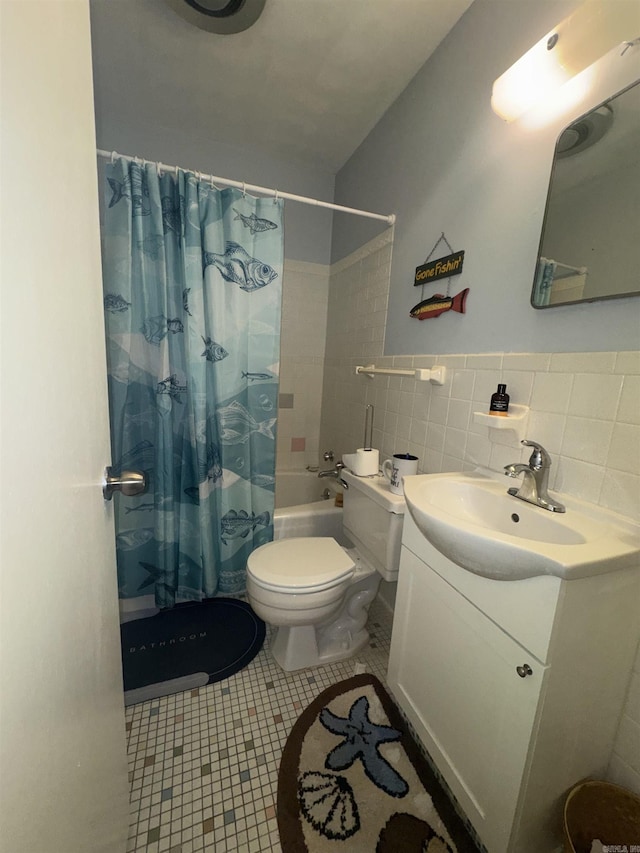 bathroom with tile patterned flooring, toilet, vanity, shower / bath combination with curtain, and tile walls