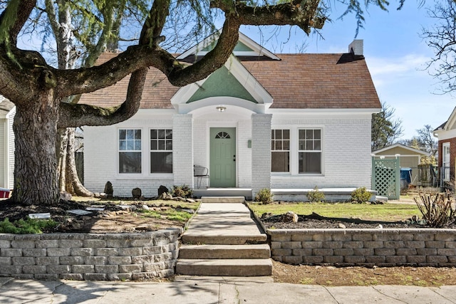 view of front of house featuring brick siding and a chimney