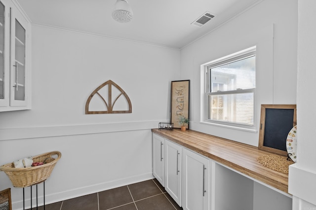 interior space with tile patterned floors, visible vents, and ornamental molding