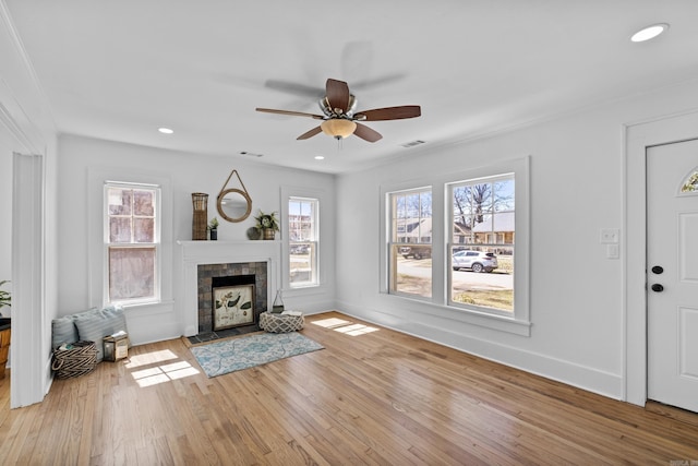 unfurnished living room with visible vents, a healthy amount of sunlight, light wood-style flooring, and a fireplace