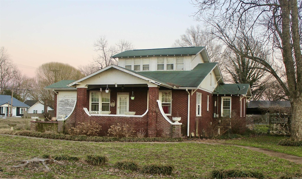 view of front of property featuring brick siding and a front yard